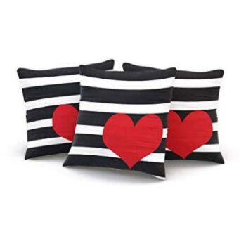 three pillows with black and white stripes and heart design